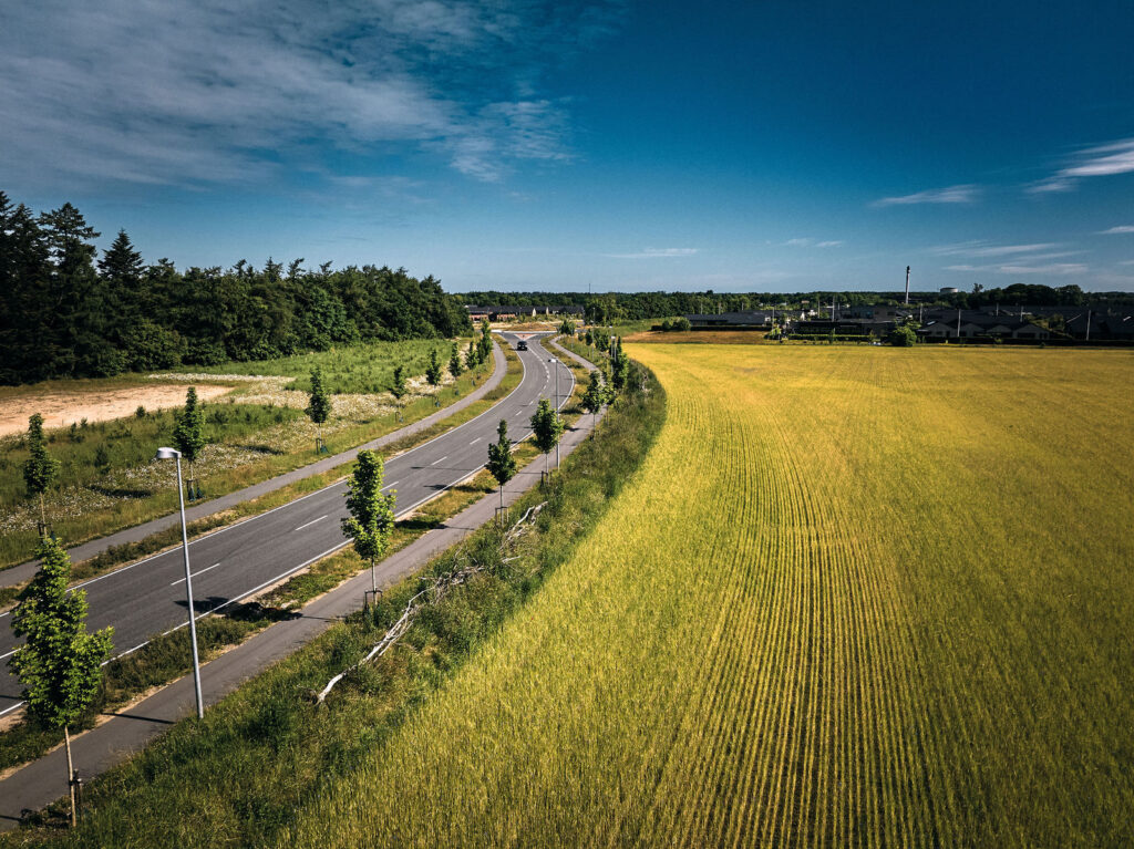 Dronefoto af vej og marker i Billund, hvor Billund Varme lægger rør