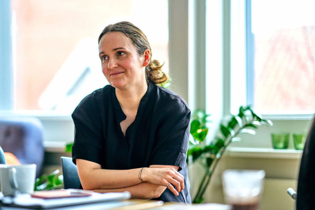 Smilende medarbejder ved mødebordet hos CFSA