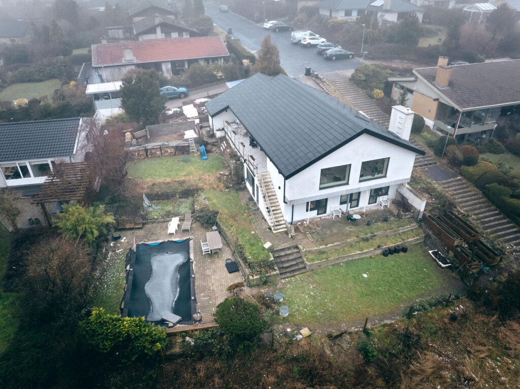 Dronefoto af Birgitte og Renés hus, hvor regnvandstanken er gravet ned i haven